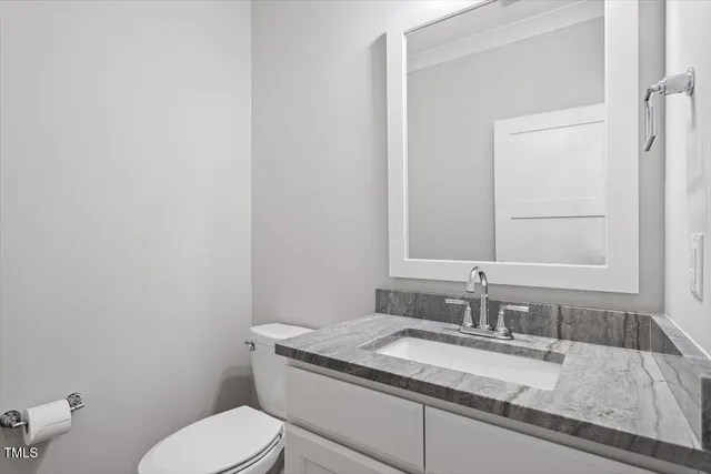 a bathroom with a granite countertop toilet sink and mirror