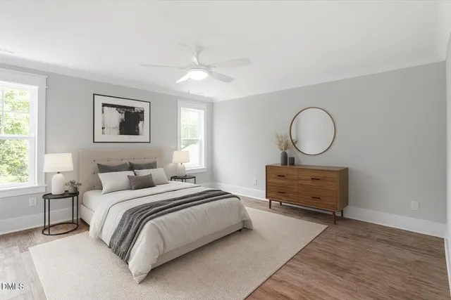 a bedroom with a bed large window with wooden floor