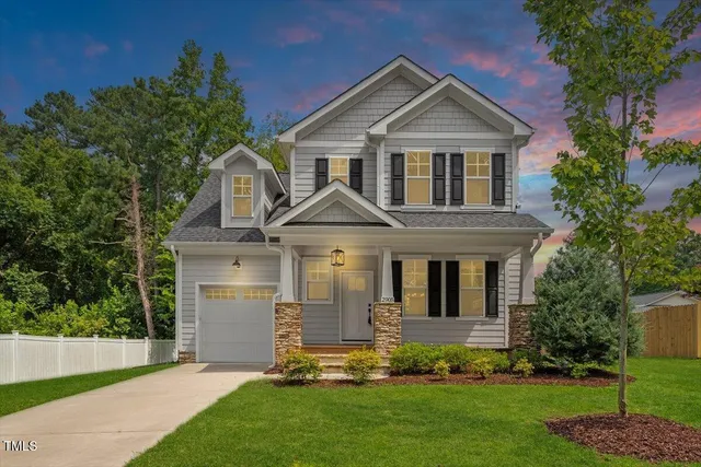 a front view of a house with a garden and plants