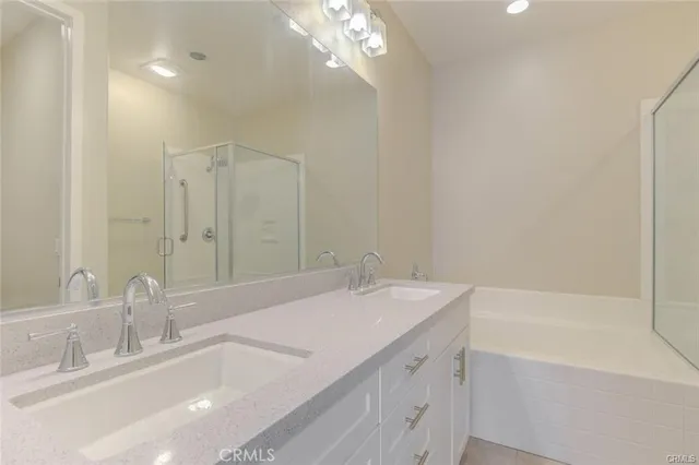 a bathroom with a sink a large mirror and a bathtub