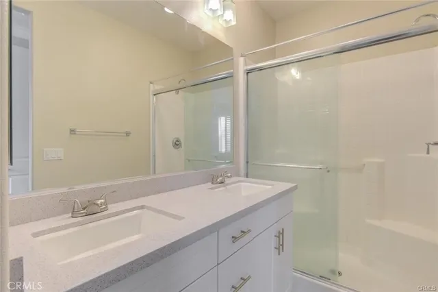 a bathroom with a sink double vanity and a mirror