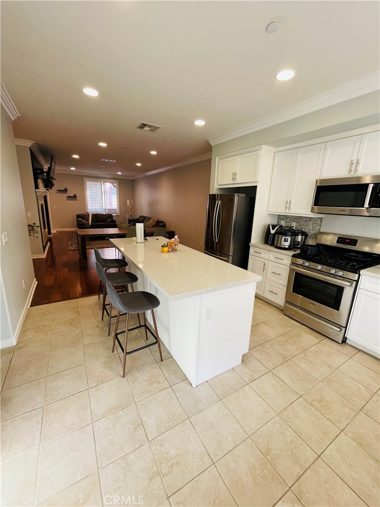 713 South Azusa Avenue, Unit D Azusa, CA 91702 - Photo 10 of 33 a kitchen with stainless steel appliances kitchen island granite countertop a refrigerator a stove a microwave oven a sink with island and chairs