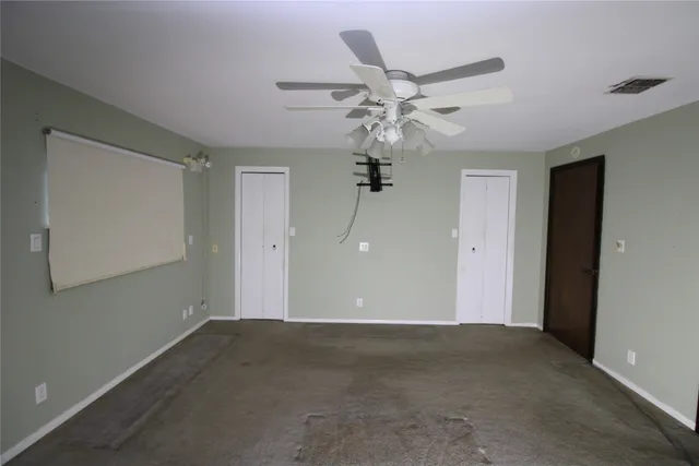 a view of a big room with chandelier fan