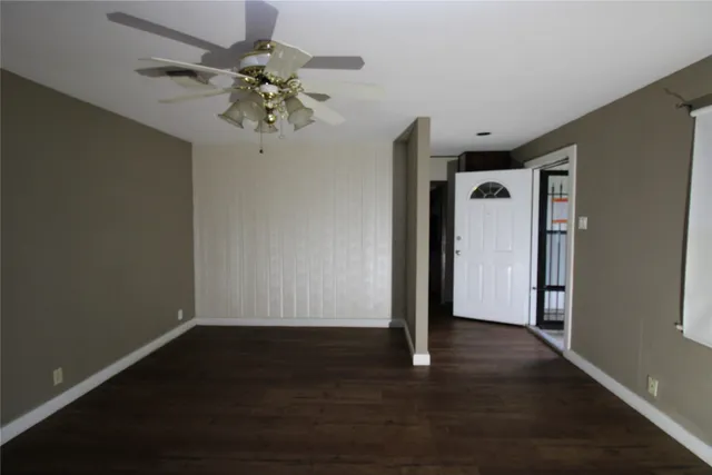 a view of a hallway with wooden floor and a chandelier