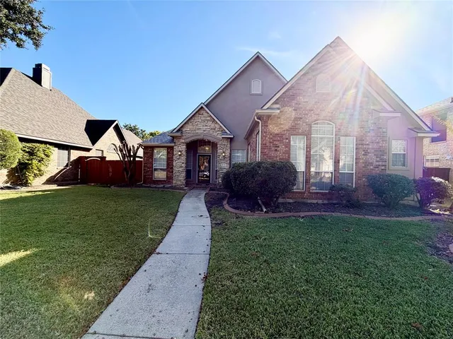 a front view of a house with a garden and trees