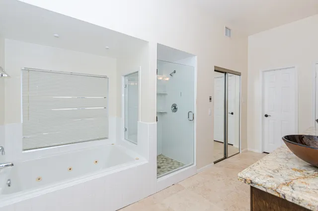 a bathroom with a granite countertop tub shower and sink