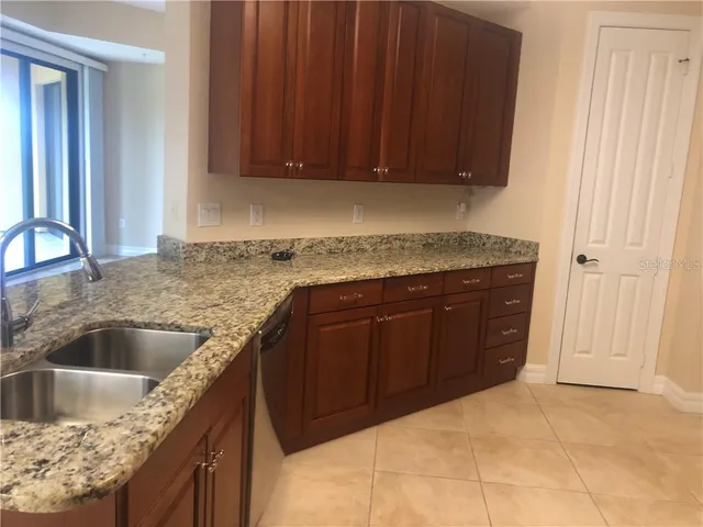 a kitchen with granite countertop a sink and cabinets
