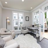 a living room with furniture a large window and a chandelier