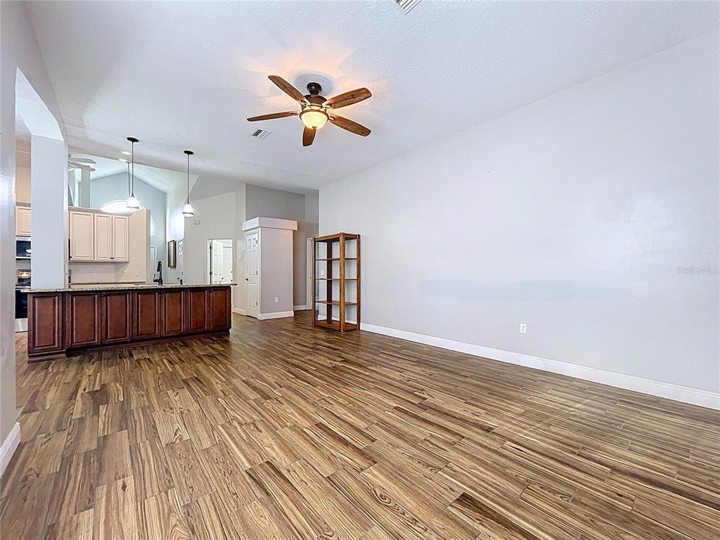 18812 Bascomb Lane Hudson, FL 34667 - Photo 24 of 57 a view of a kitchen with wooden floor and a ceiling fan
