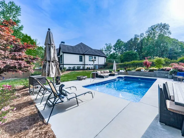 a view of swimming pool with outdoor seating and plants