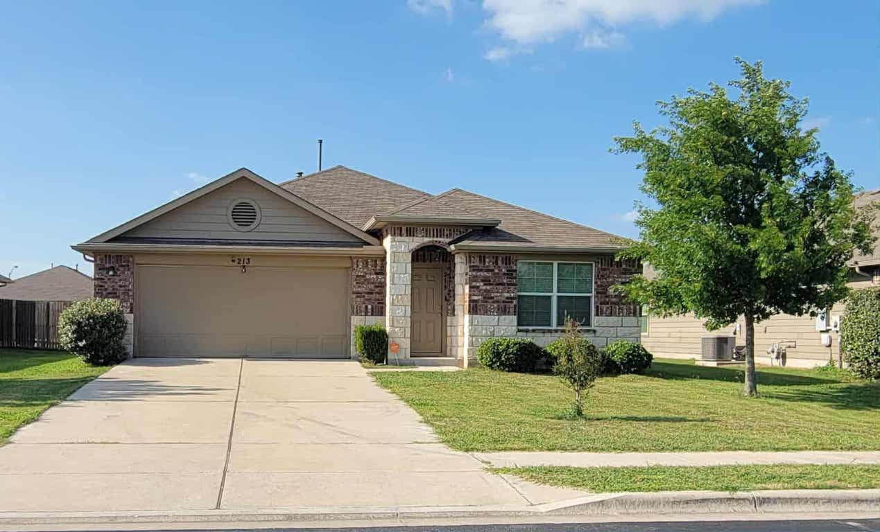 213 Camellia Drive Hutto, TX 78634 - Photo 1 of 27 a front view of a house with a yard and potted plants