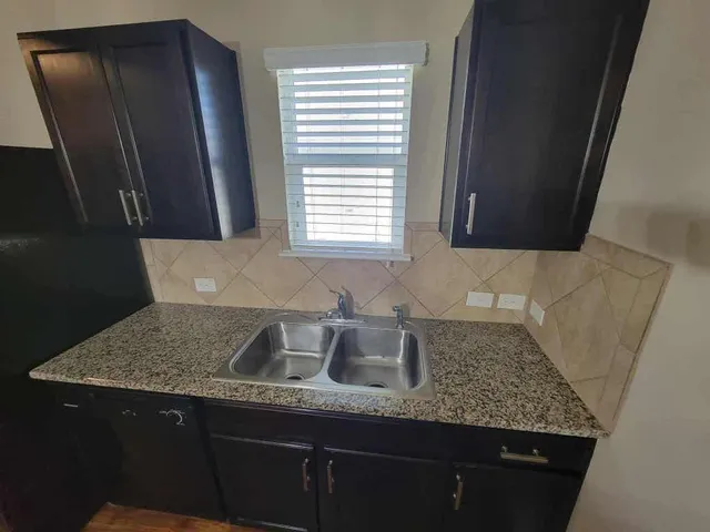 a kitchen with granite countertop a sink and a window