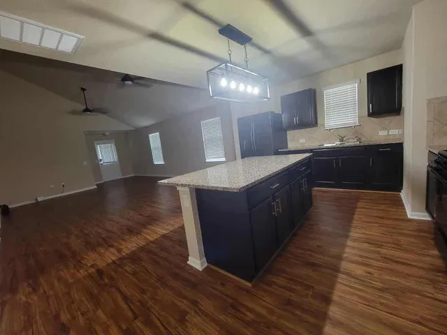 a large kitchen with wooden floors and stainless steel appliances