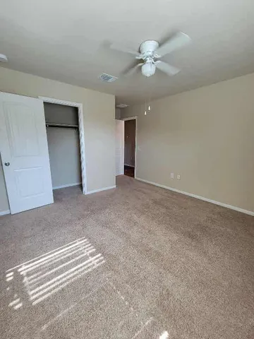 a view of an empty room with a ceiling fan