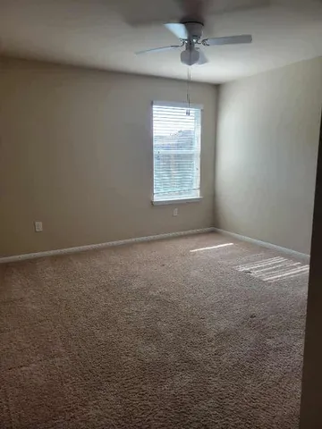 en empty room with windows and ceiling fan