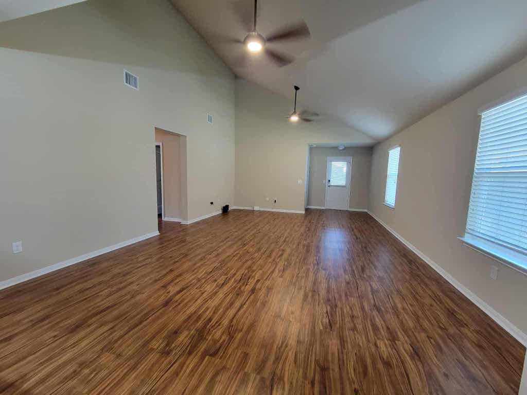 213 Camellia Drive Hutto, TX 78634 - Photo 27 of 27 an empty room with wooden floor and windows