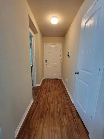 a view of a hallway with wooden floor
