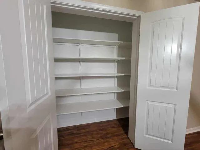 a view of walk in closet with empty racks
