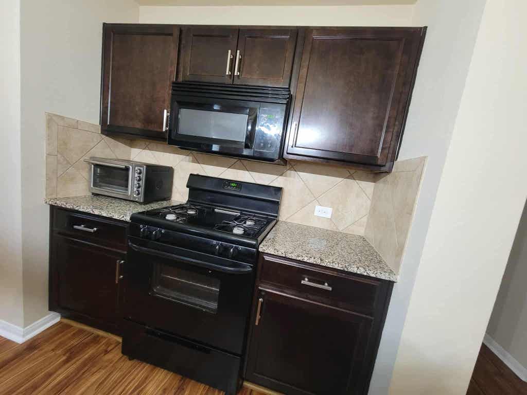 213 Camellia Drive Hutto, TX 78634 - Photo 8 of 27 a kitchen with granite countertop wooden cabinets and stainless steel appliances