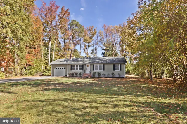 a view of a big house with a big yard and large trees