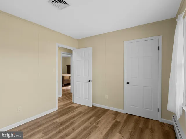 a view of an empty room with closet and a window