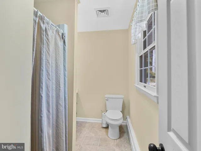 a white toilet sitting next to a white sink and vanity
