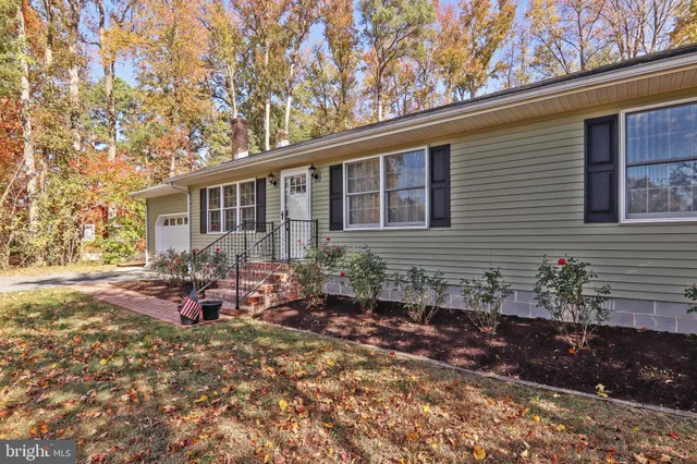 a front view of a house with a yard and trees