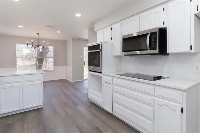 a kitchen with stainless steel appliances white cabinets and a microwave oven