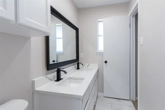 a bathroom with a sink toilet and mirror