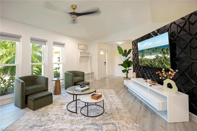 a living room with furniture a flat screen tv and a large window