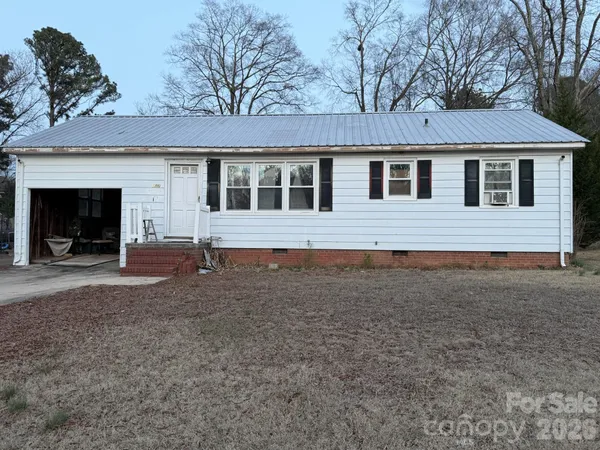 a front view of a house with yard and parking