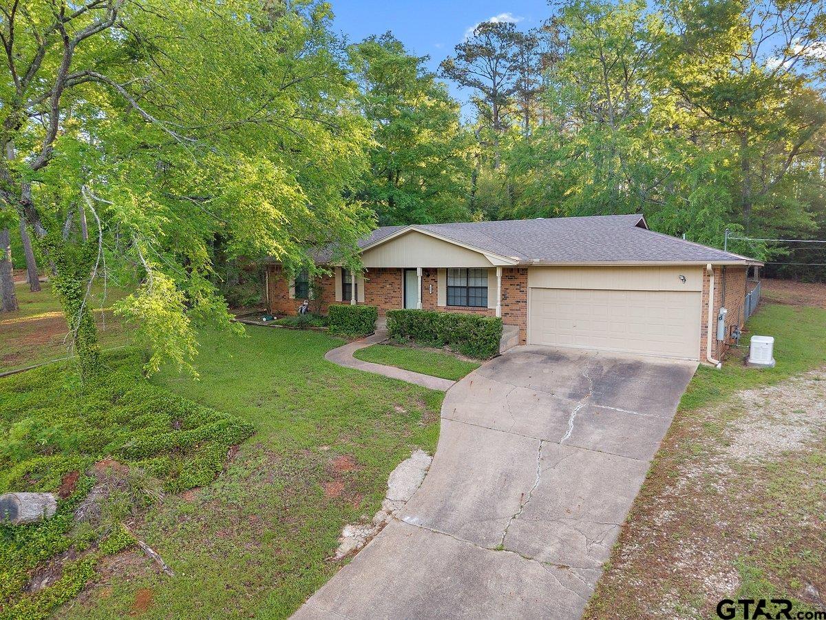 a front view of a house with a yard and trees