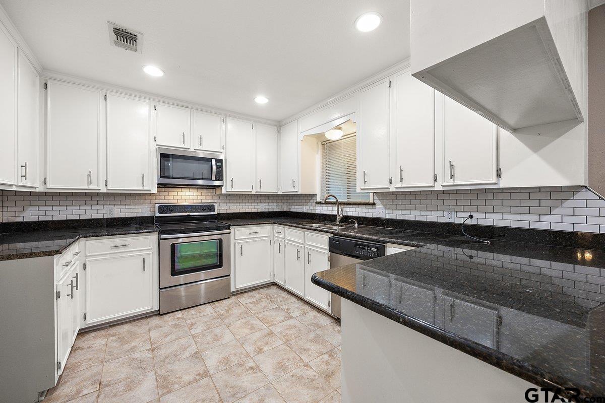 133 Caroline Street Rusk, TX 75785 - Photo 9 of 21 a kitchen with granite countertop a sink a stove and cabinets