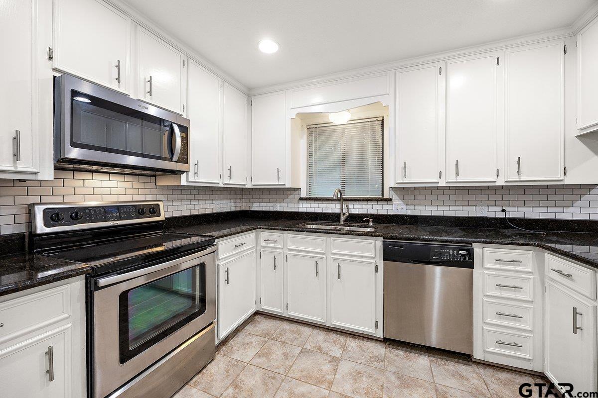 133 Caroline Street Rusk, TX 75785 - Photo 10 of 21 a kitchen with granite countertop a stove microwave sink and cabinets