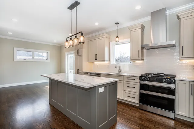 a kitchen with stainless steel appliances granite countertop a sink stove and refrigerator
