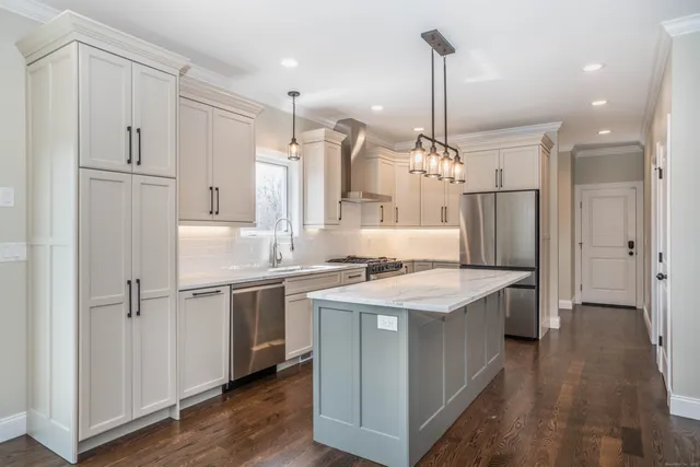 a kitchen with kitchen island white cabinets and refrigerator