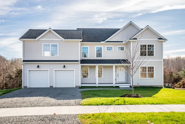 a front view of a house with a yard and garage