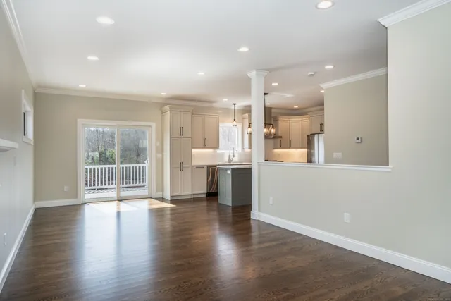 an open kitchen with white cabinets and wooden floor