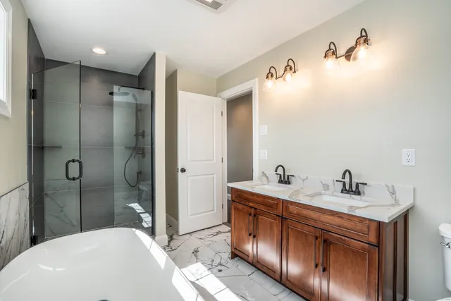 a bathroom with a sink a toilet and shower