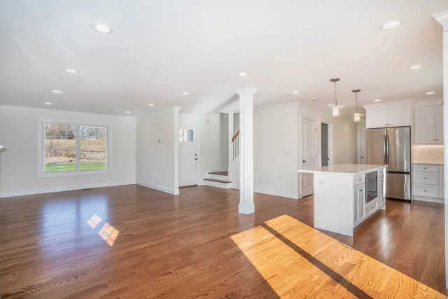 a view of a living room and kitchen with a wooden floor