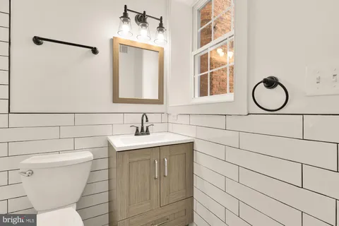 a bathroom with a toilet sink and mirror