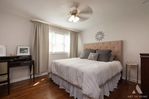 a bedroom with bed and wooden floor