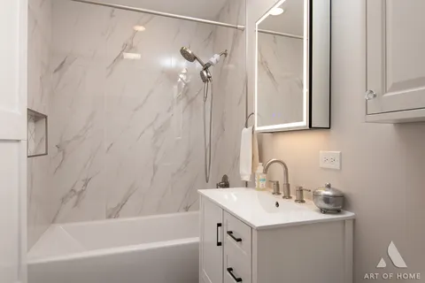 a bathroom with a sink a mirror and a bathtub