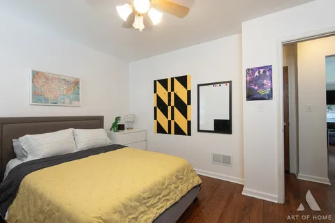 a bedroom with a bed and a painting on the wall