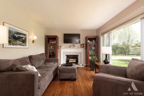 a living room with furniture fireplace and a large window