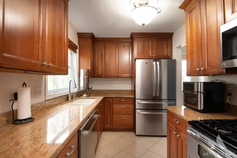 a kitchen with stainless steel appliances granite countertop a refrigerator stove and sink