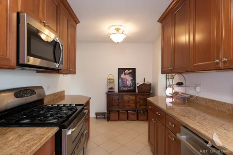 a kitchen with granite countertop a stove a sink and a microwave
