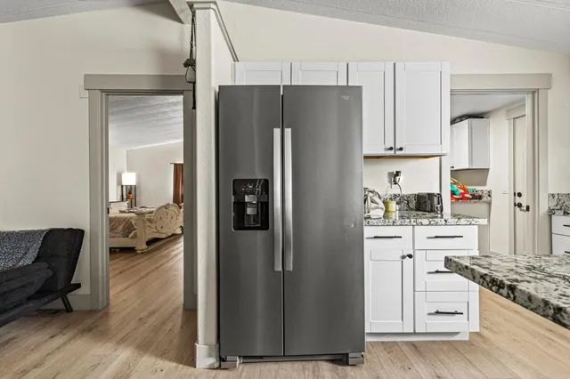 a living room with furniture kitchen and a wooden floor