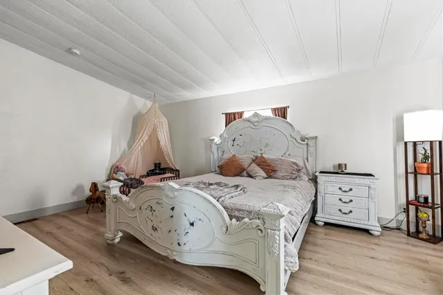 a view of a hallway with bathroom and mirror