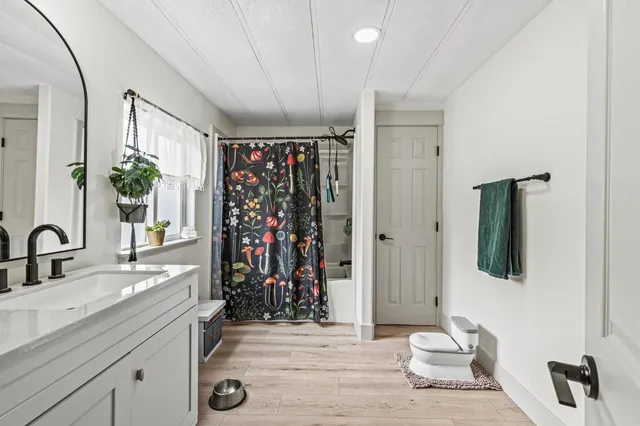 a spacious bathroom with a toilet sink and mirror